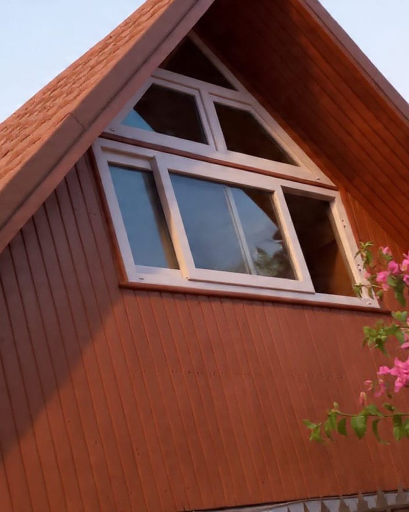 Ventana de PVC blanca en buhardilla triangular de techo