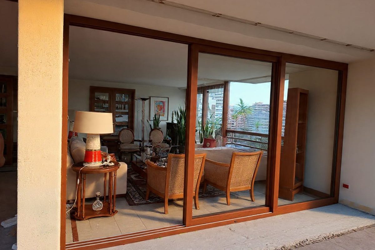 Living con puertas correderas de PVC y vista a balcón con vegetación
