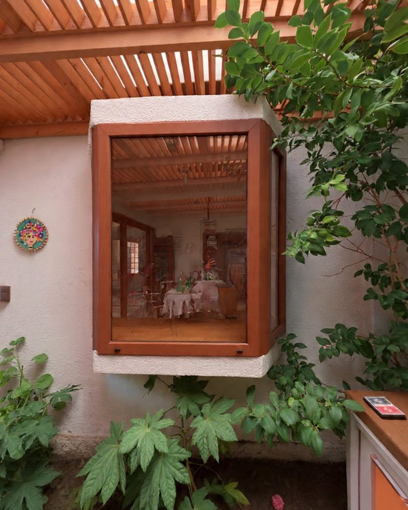 Ventana mirador de PVC color madera integrada a pérgola y jardín