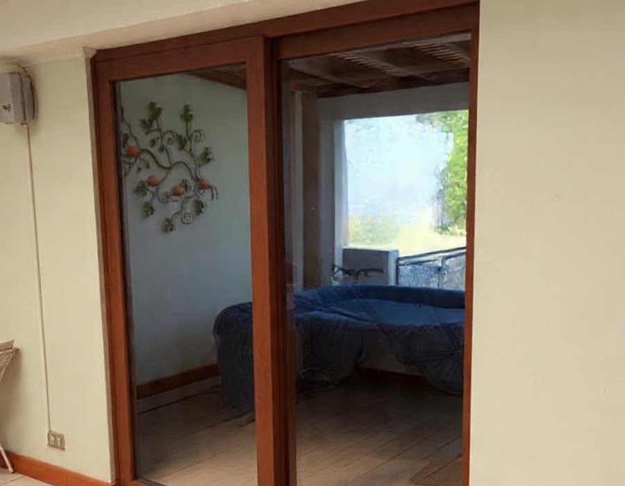 Puerta corredera de PVC color madera con acceso a dormitorio